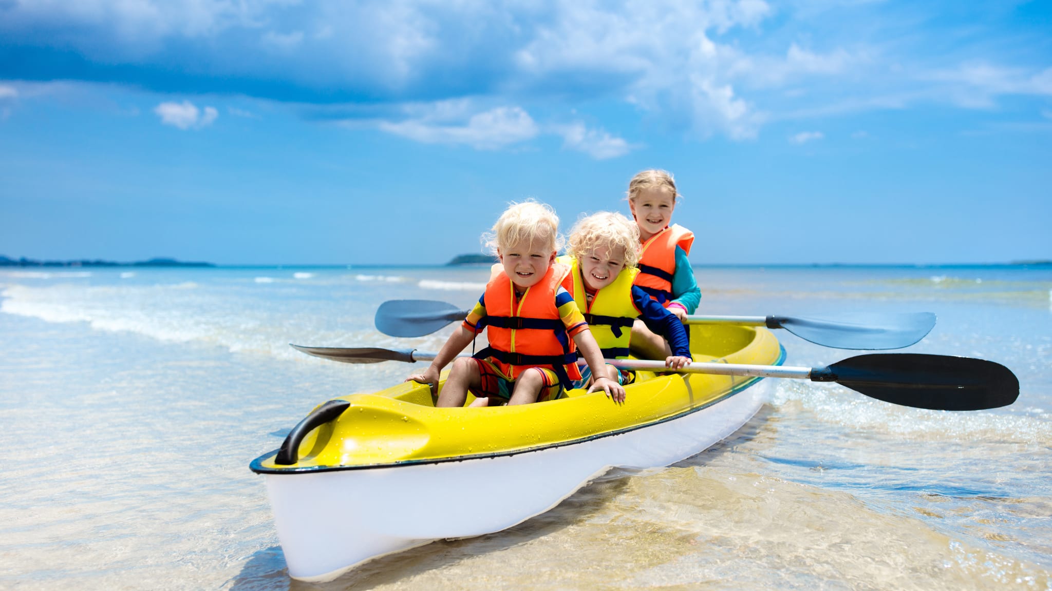 Kinder fahren Kanu im Meer