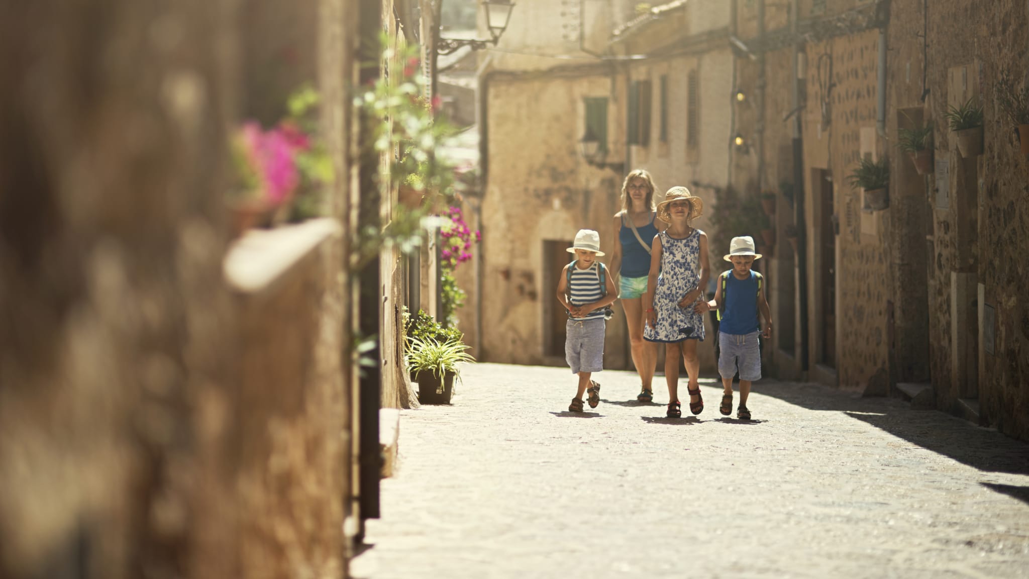 Mutter spaziert mit Kindern durch die Altstadt von Valdemossa auf Mallorca, Spanien
