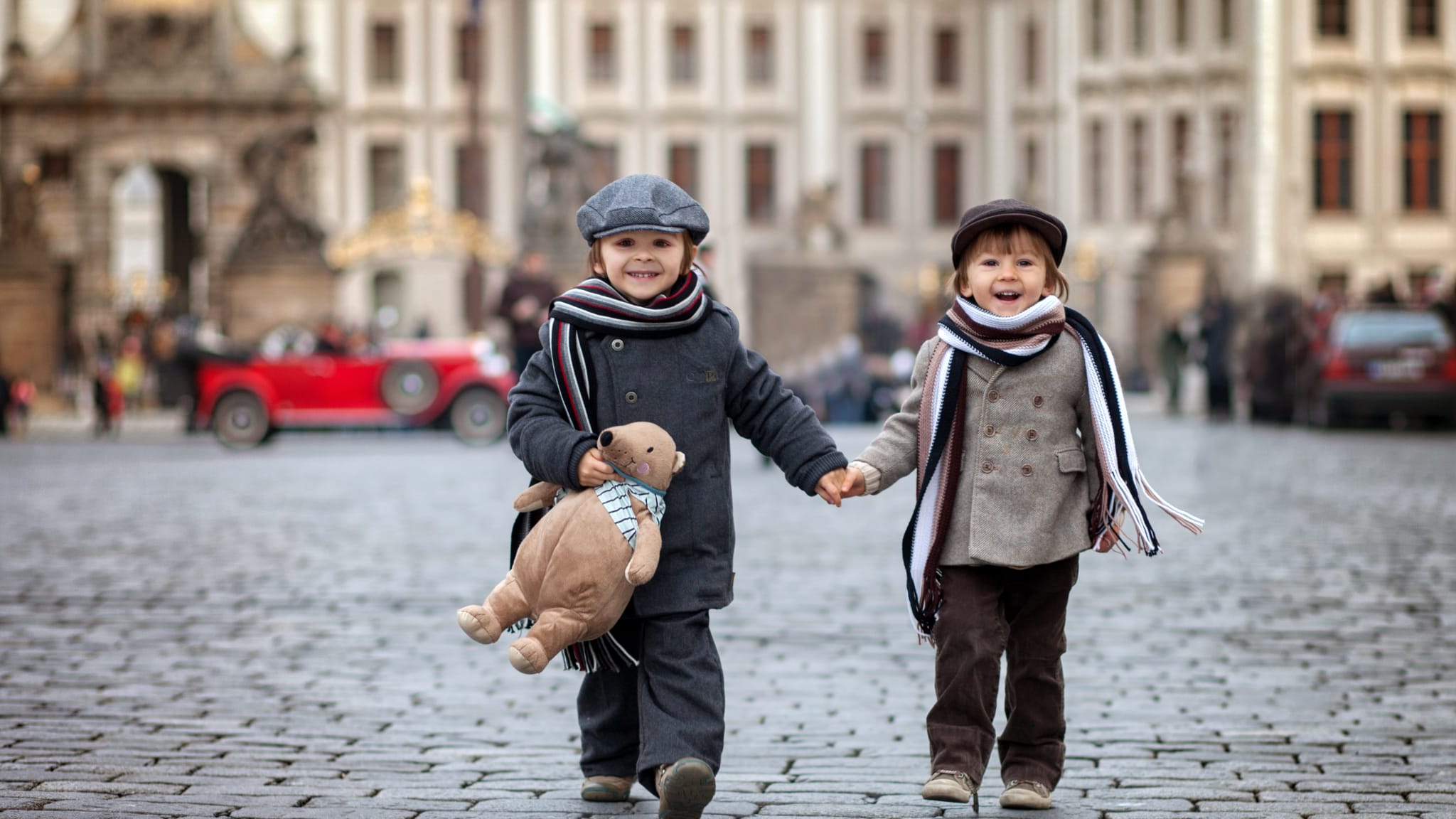 Geschwister laufen Hand in Hand duch die Altstadt von Prag, Tschechien