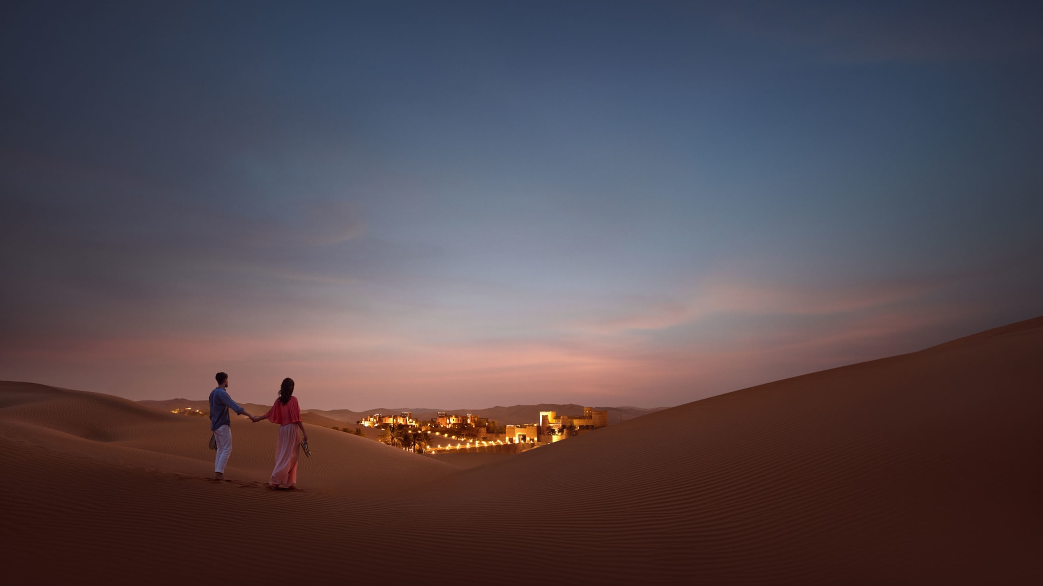 Zwei Spaziergänger im Wüstensand bei Abenddämmerung in Abu Dhabi