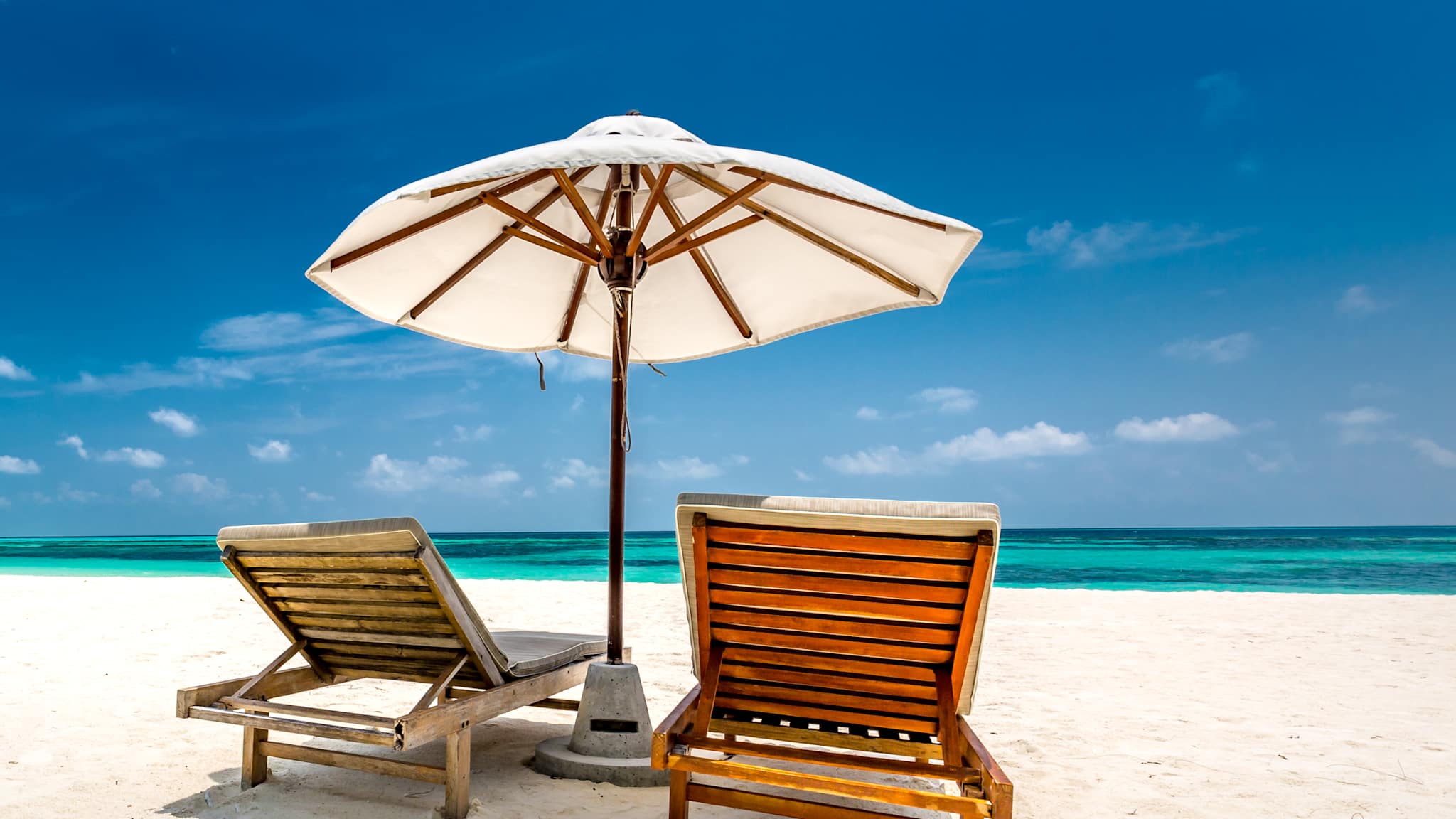 Liegen mit Sonnenschirm am Strand