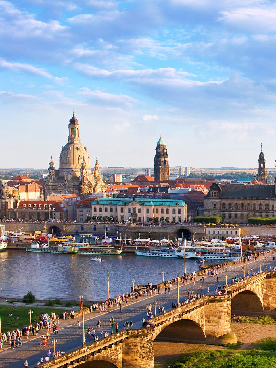 Blick auf eine Brücke und die Altstadt von Dresden mit zahlreichen Türmen und Kuppeln