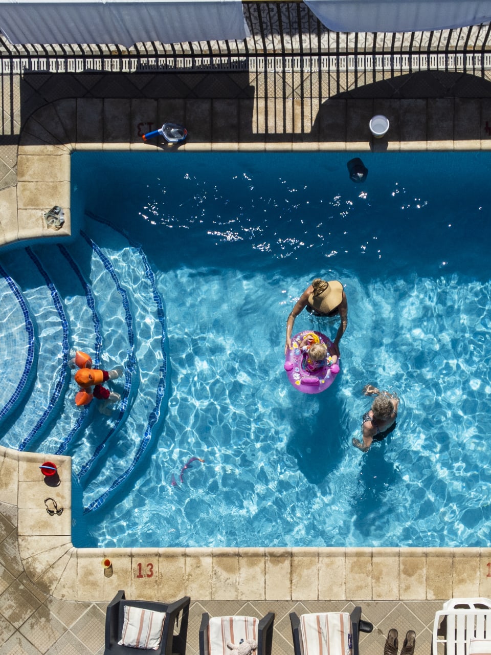 Aufnahme einer altersgemischten Familie in und um ein Schwimmbad auf Teneriffa © iStock.com/SolStock