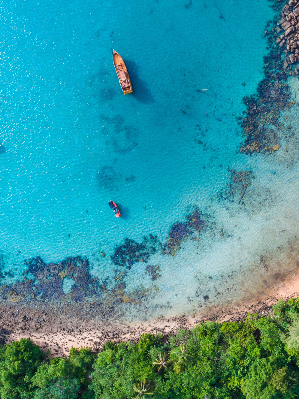 Luftaufnahme von einem Strand auf Malta mit türkisem Wasser und Booten © iStock.com/themorningglory