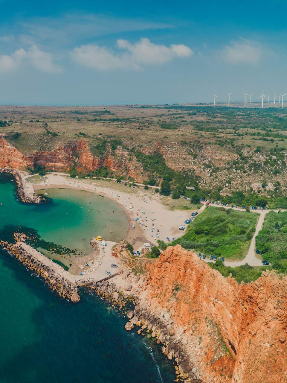 Luftaufnahme des Bolata-Strands mit geschwungener Bucht, Sandstrand und roten Klippen am Kap Kaliakra in Bulgarien