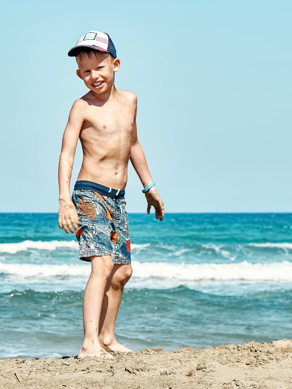 Lustige fröhliche kleine Brüder spielen an Sandstrand am Meer ©iStock.com/timltv