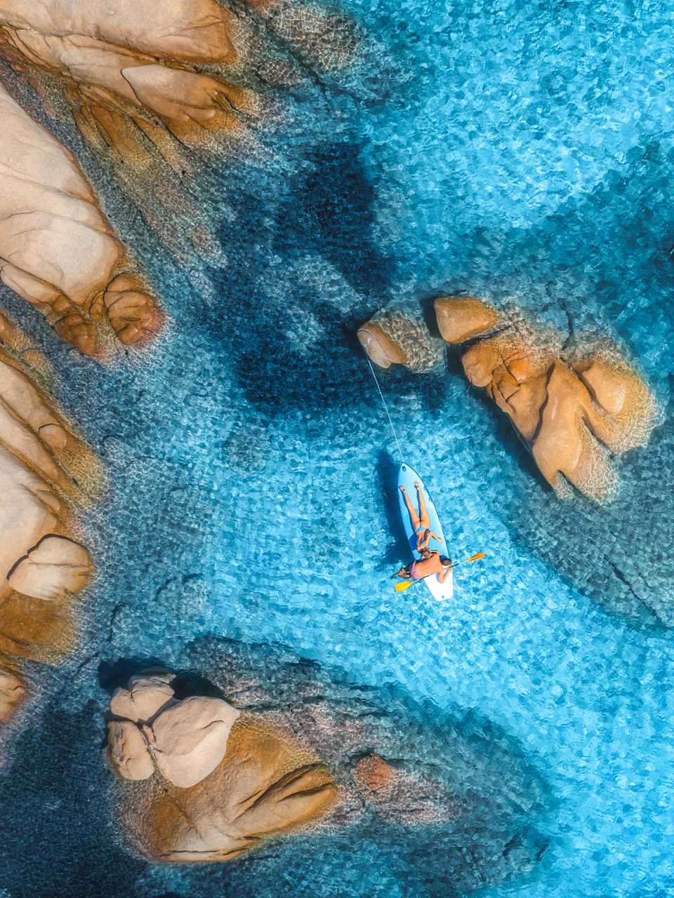 Menschen auf schwimmendem Kanu im transparenten azurblauen Wasser, Insel Sardinien © iStock.com/den-belitsky