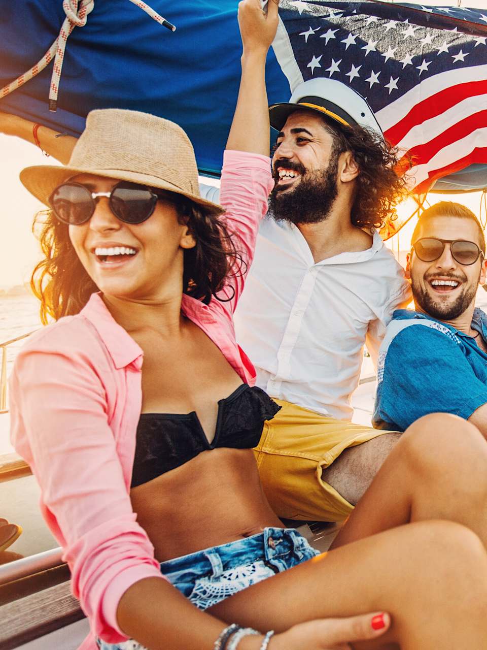 Menschen mit USA-Flagge auf einer Yacht. © Petar Chernaev/E+ via Getty Images