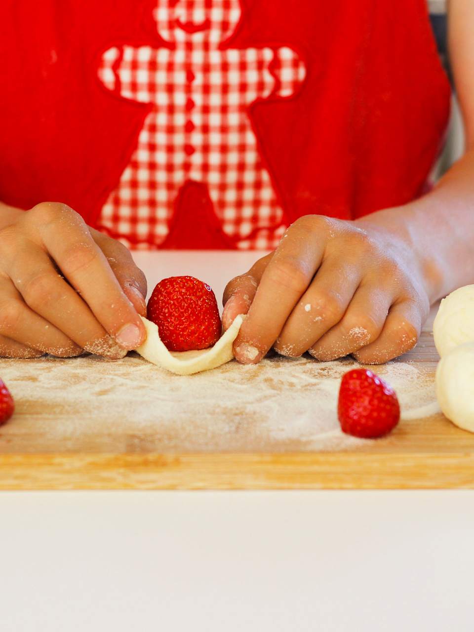Eine Frau arbeitet Erdbeeren in Knödel ein für die süßen, fruchtigen tschechischen Knödel Ovocné knedlíky.