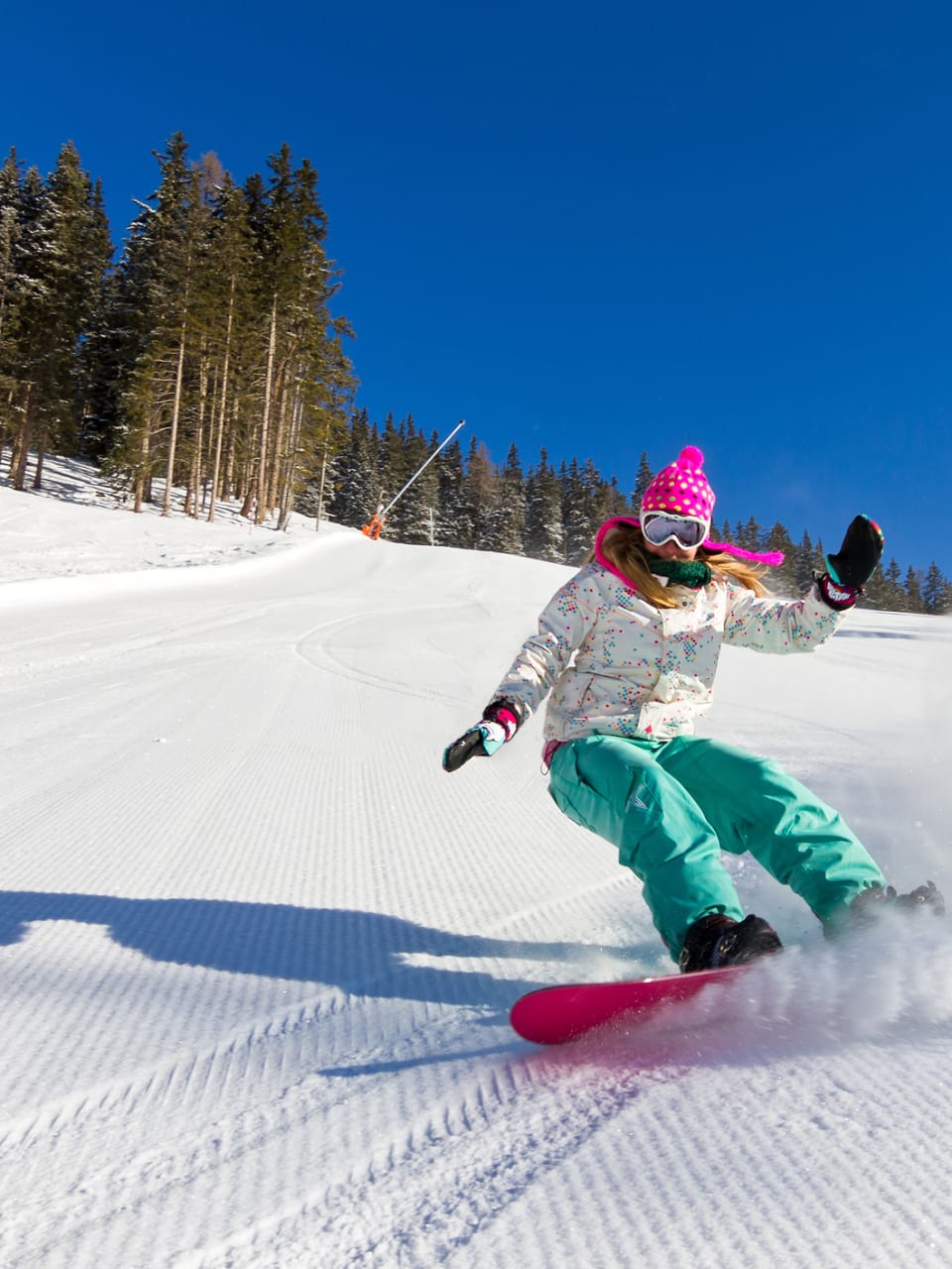 Snowboarderin auf der Piste an einem sonnigen Morgen in den italienischen Alpen © iStock.com/dennisvdw