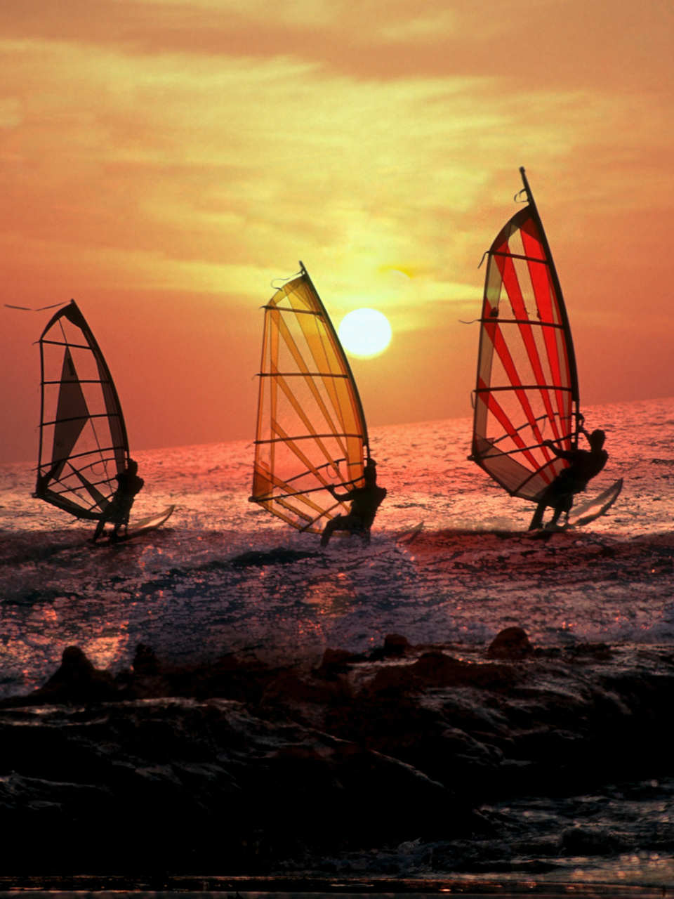 Surfen bei Sonnenuntergang in Terifa, Spanien © iStock.com/ManuelVelasco
