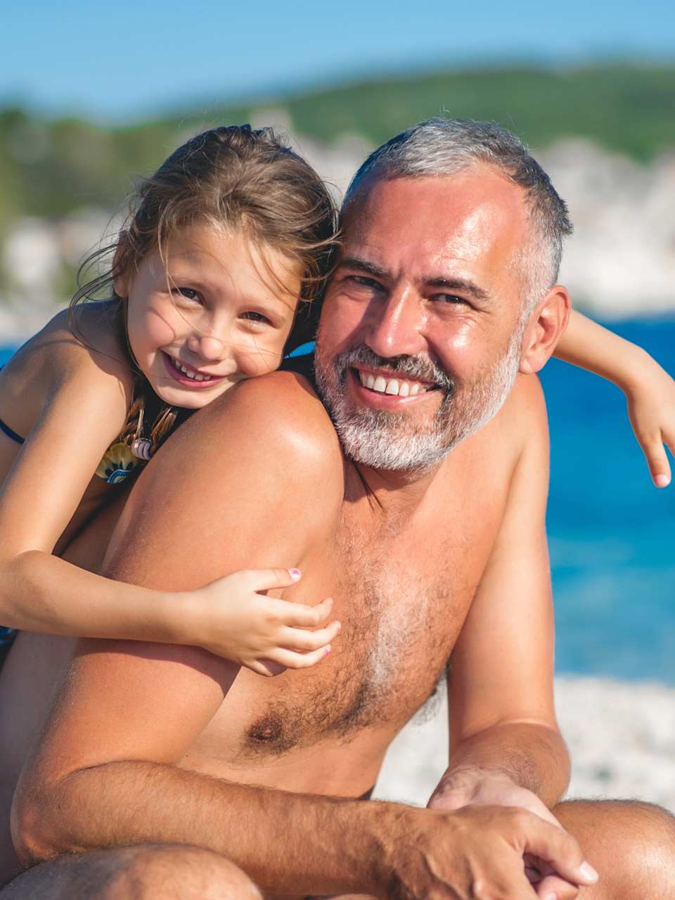 Vater mit seiner Tochter beim Strandurlaub ©CasarsaGuru/iStock