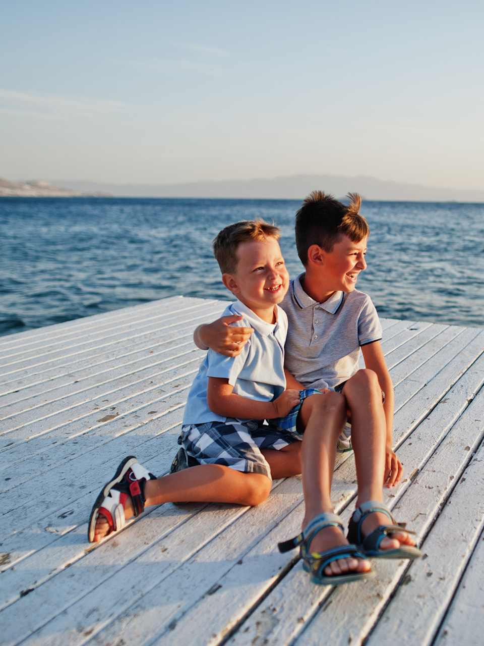Zwei Brüder sitzen im Türkei Resort am Pier am Mittelmeer ©iStock.com/ASphotowed