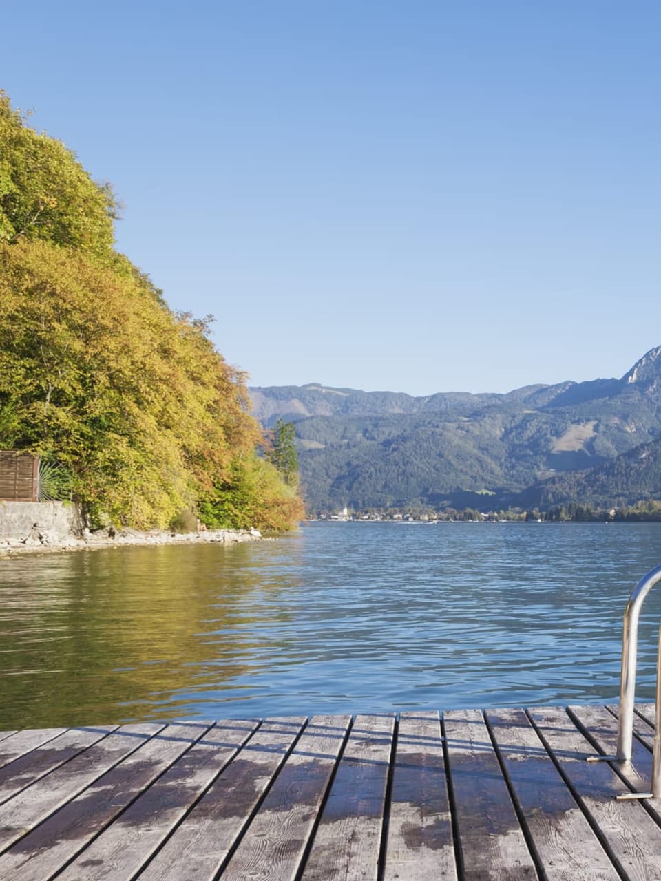Ein Badesee mit Bergen im Hintergrund im Salzburger Land, Österreich.