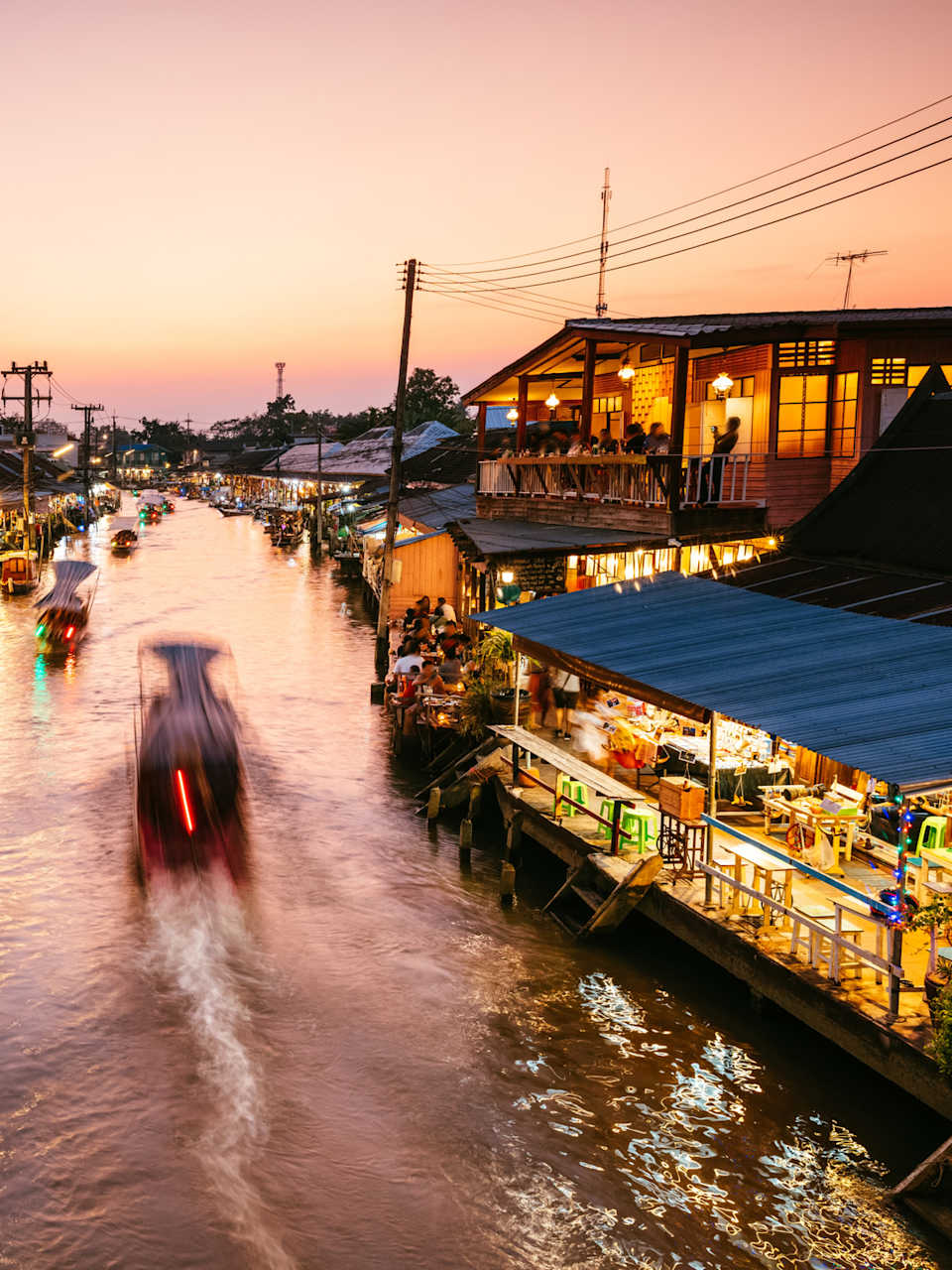 Ein schwimmender Markt in Bangkok, Thailand, im Sonnenuntergang.
