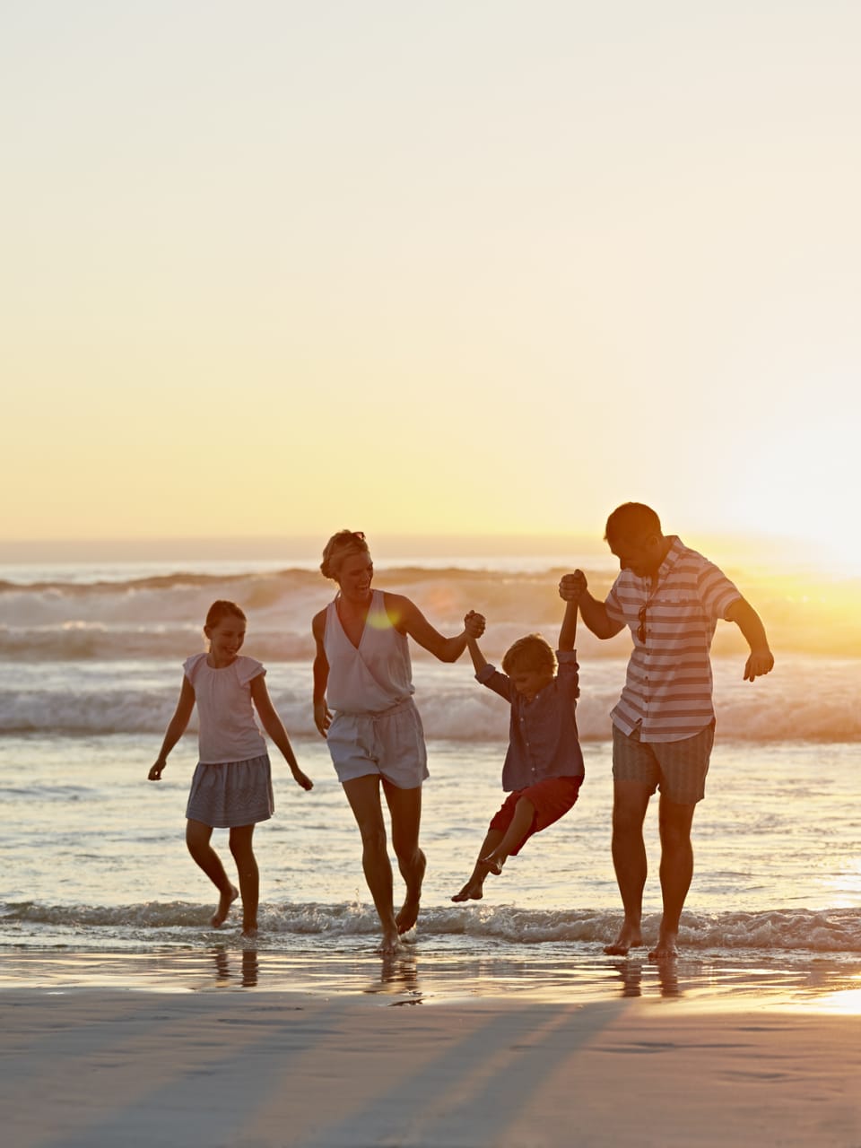 Eine Familie beim Sonnenuntergang am Strand.
