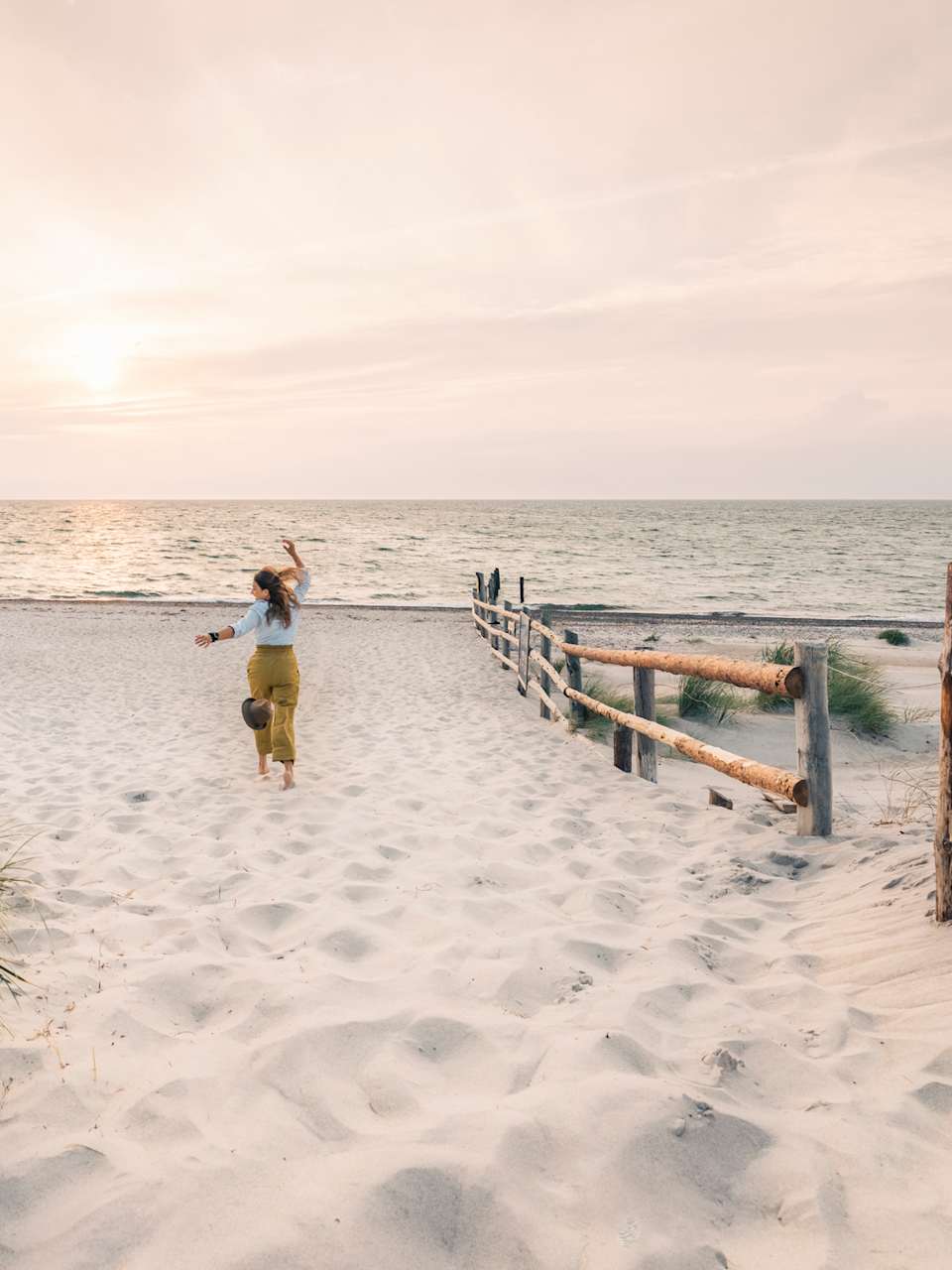Eine Frau rennt einen Strand in Mecklenburg-Vorpommern, Deutschland, entlang. © Francesco Vaninetti Photo/Moment via Getty Images