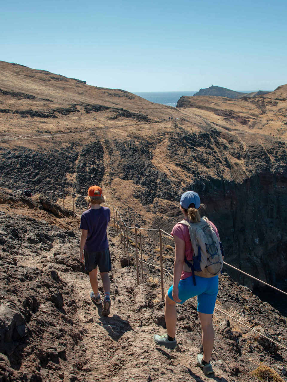 Eine Frau und ein Junge wandern an der Küste von Madeira.
