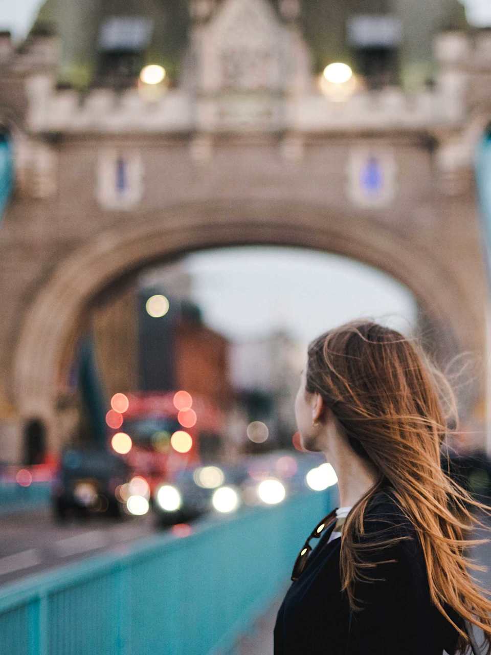 Eine junge Frau steht auf der Tower Bridge in London.