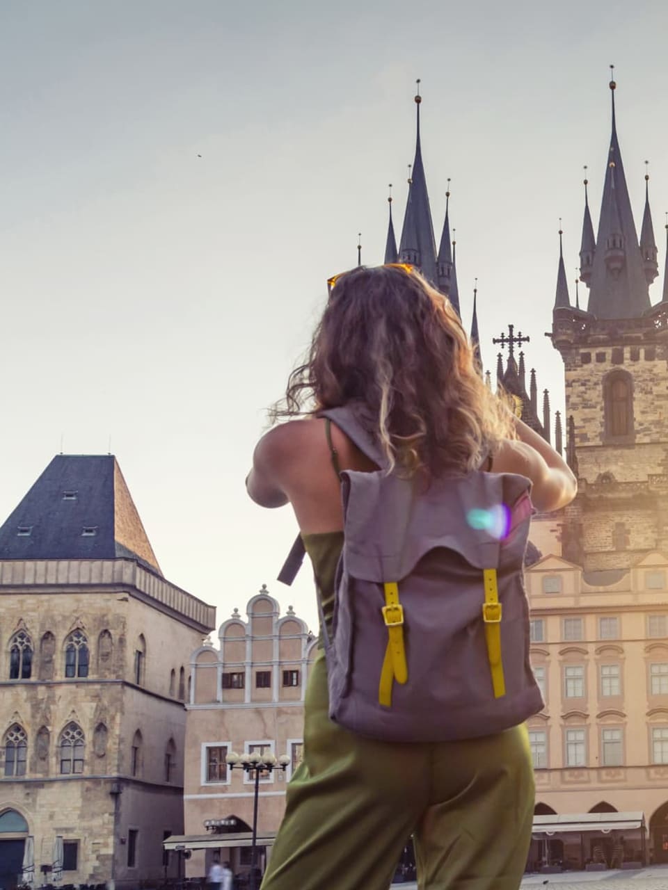 Eine junge Frau macht ein Foto der Tyn Kirche in Prag.
