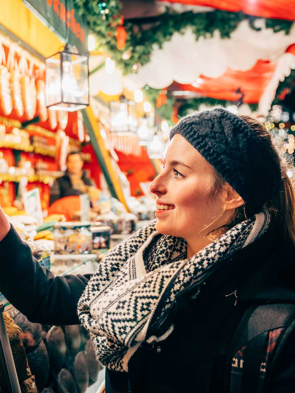 Eine Frau lächelt ein Lebkuchenherz an.