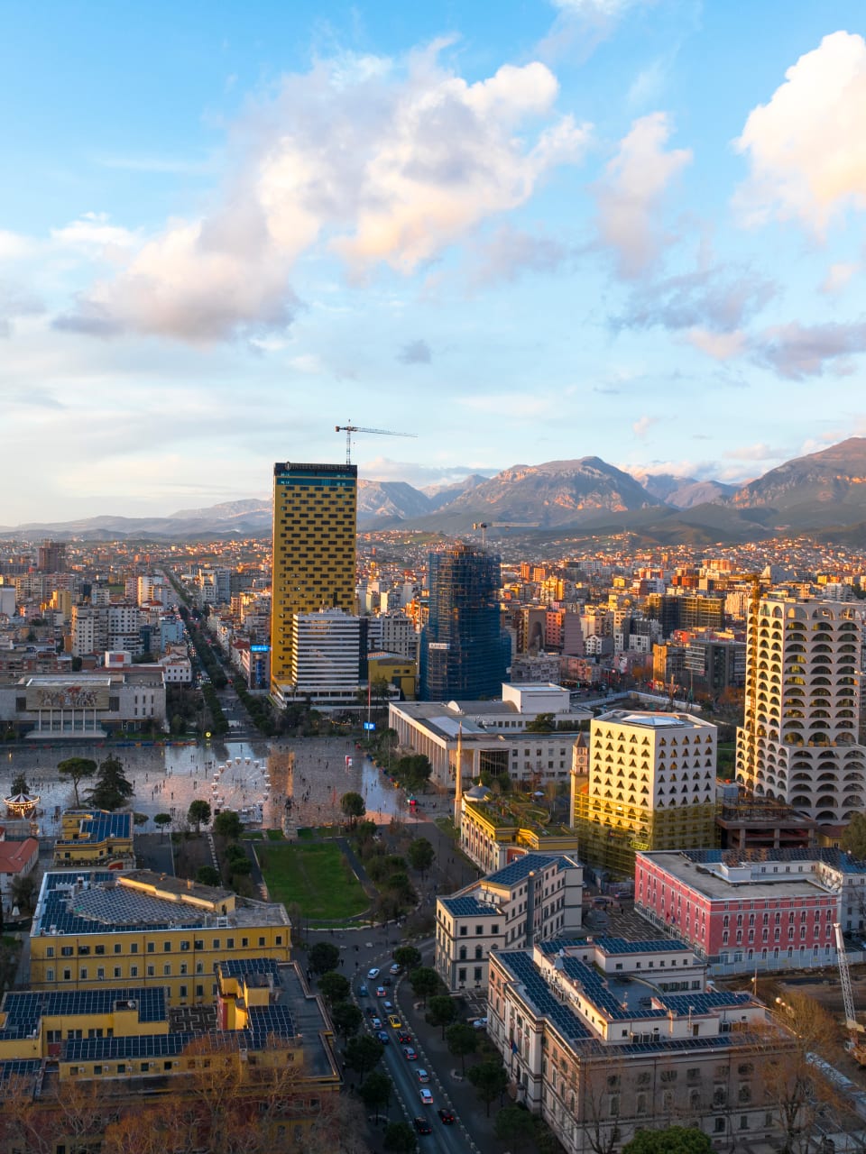 Blick über die Skyline von Tirana mit Bergen im Hintergrund.
