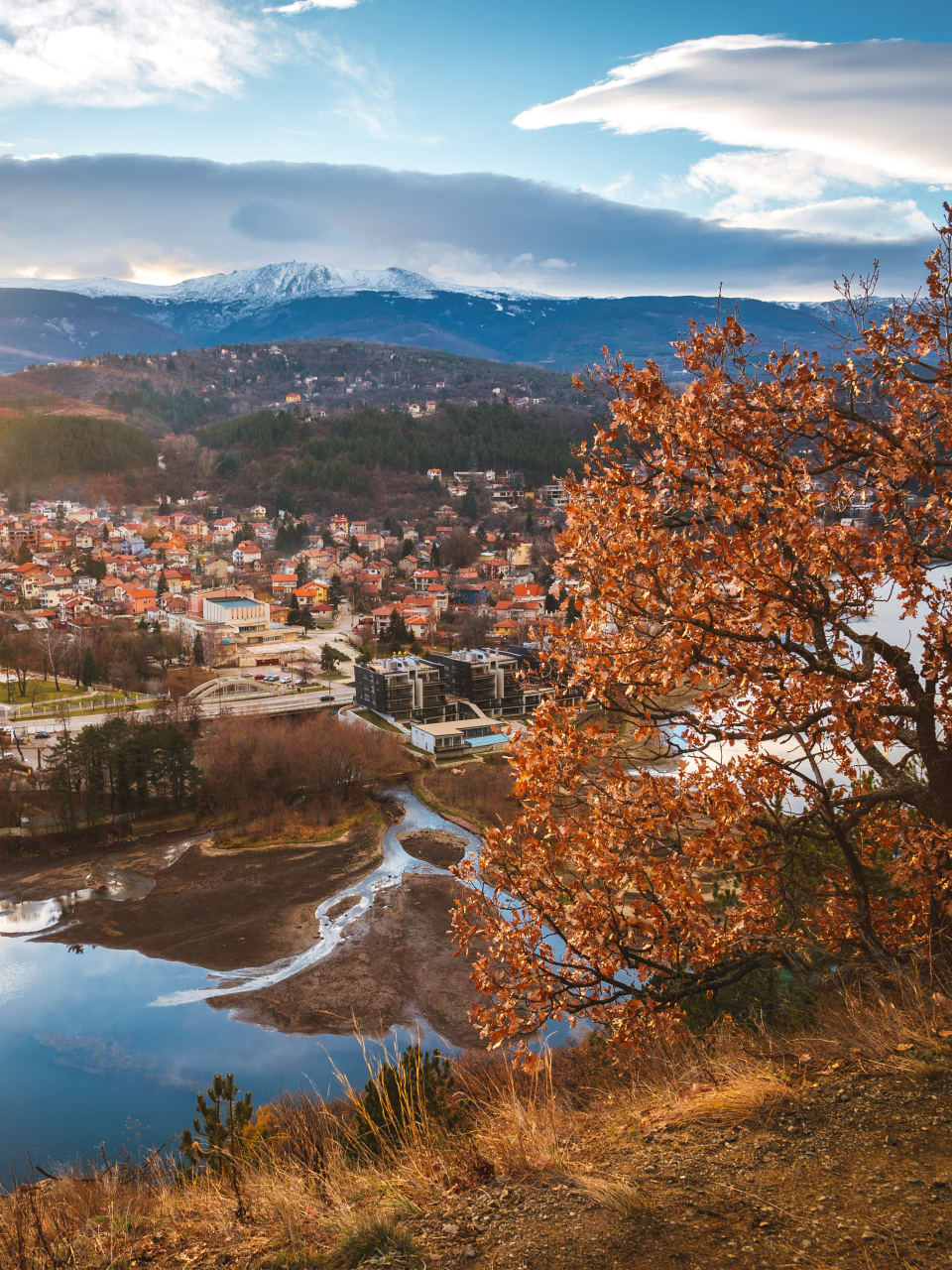 Eine Stadt in der Ferne mit Bergen im Hintergrund