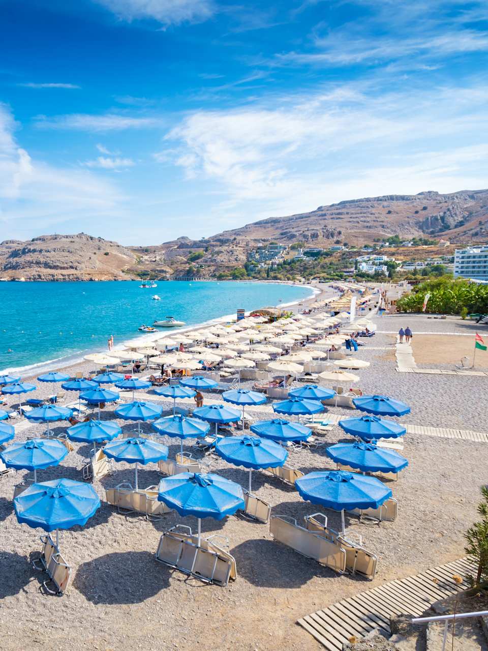 Ein weiter Strand mit blauen Sonnenschirmen