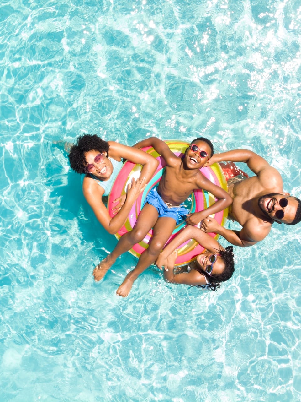 Familie im Pool im Sommerurlaub