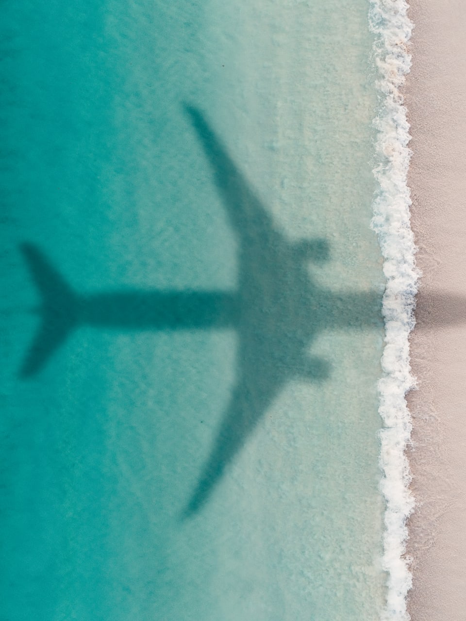 Flugzeug fliegt über Strand.