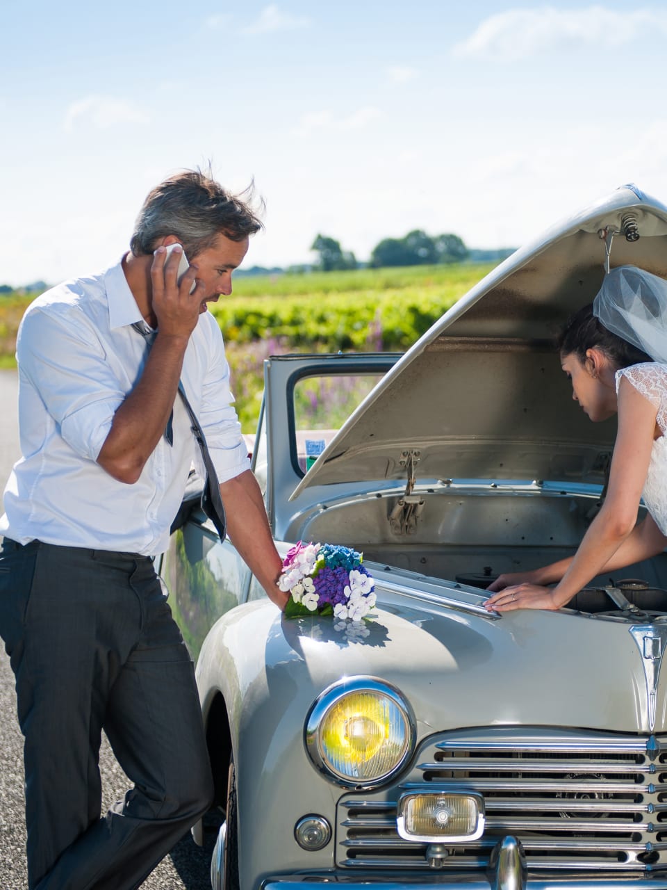 Ein Paar hat eine Panne mit dem Hochzeitsauto.