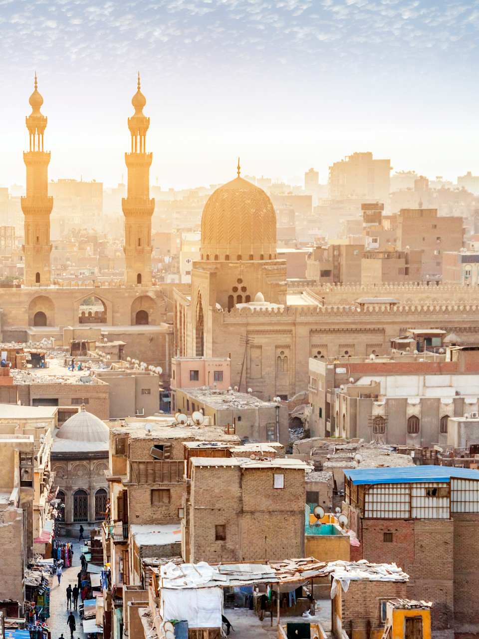 Die Innenstadt von Kairo, Ägypten erstrahlt im Sonnenschein, es sind viele Gebäude und Türme zu sehen.