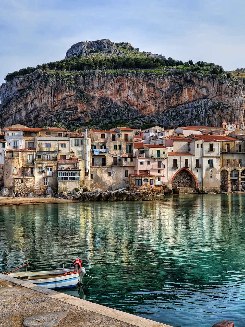 Sea By Old Buildings In Cefalu Against Sky