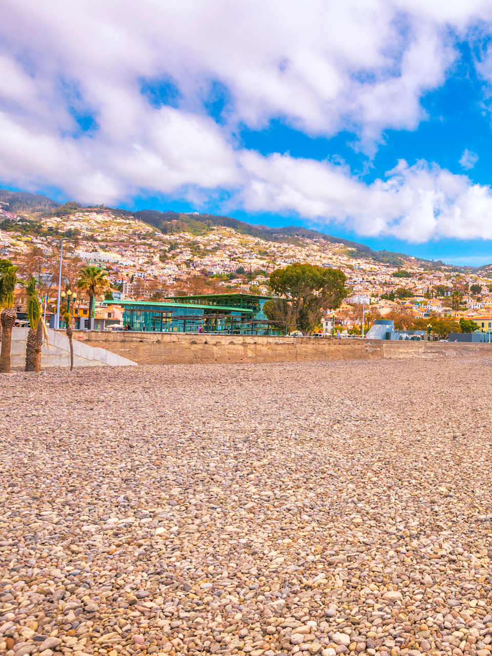Ein Kiesstrand mit bergiger Landschaft im Hintergrund