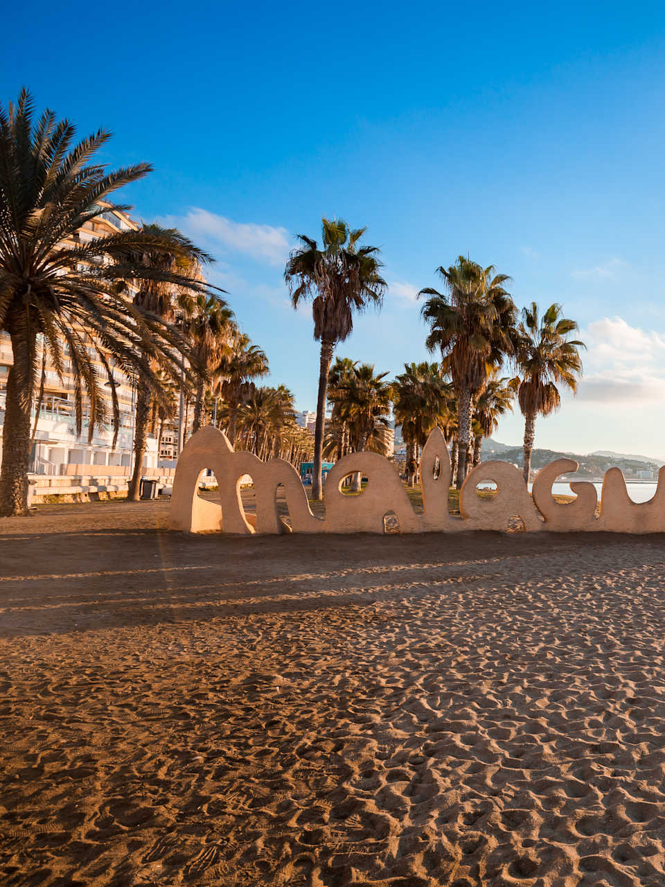 Ein Strand mit Palmen und einer Buchstaben-Statue