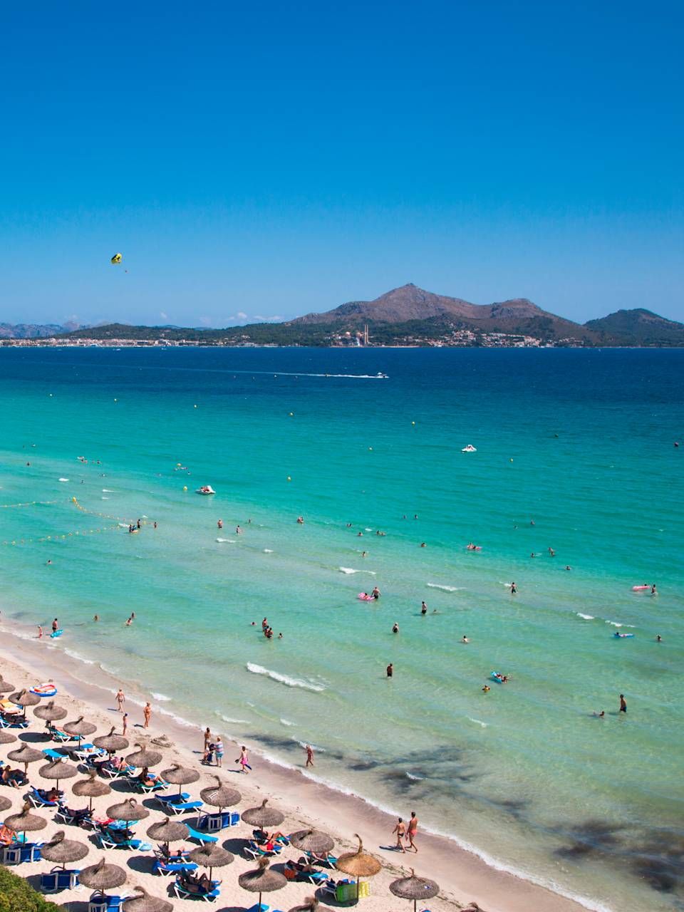 Sonnenschirme und Menschen am Playa de Muro auf Mallorca, Spanien