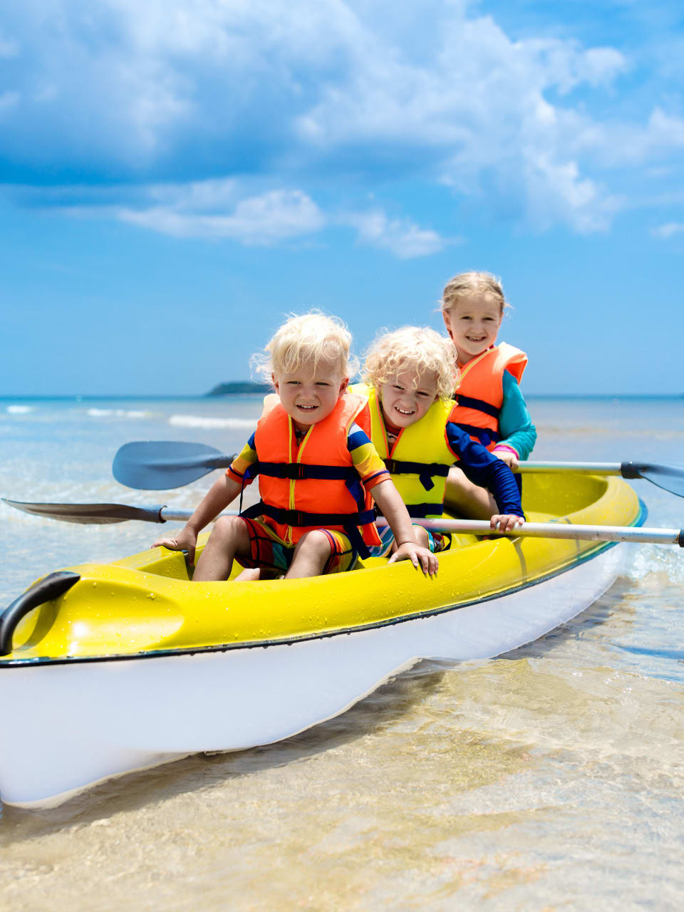 Kinder fahren Kanu im Meer