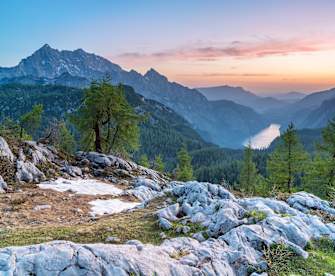 Blick auf ein Gebirge mit Bäumen bei Sonnenuntergang