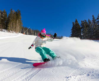 Snowboarderin auf der Piste an einem sonnigen Morgen in den italienischen Alpen © iStock.com/dennisvdw