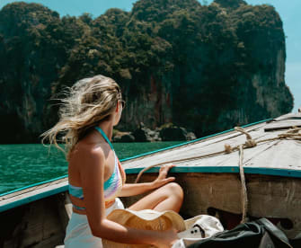 Eine junge Frau sitzt im thailändischen Boot auf dem Weg nach Krabi, Thailand.