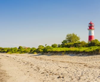 Ein Leuchtturm an einem Strand in Schleswig-Holstein, Deutschland. © Westend61/Westend61 via Getty Images
