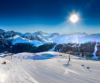 Blick auf einen Skilift zwischen verschneiten Bergen