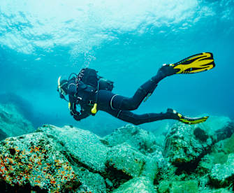männlicher Taucher genießt blaues flaches Wasser © iStock.com/ultramarinfoto