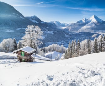 Panoramablick auf die Bergwelt mit einer Hütte in den Alpen.