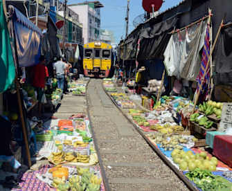 In der Nähe von Bangkok müssen die HändlerInnen des "Mae Klong" ihre Ware regelmäßig vor einem Zug in Sicherheit bringen. © amnat30/ SHutterstock.com