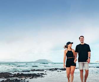 Ein Paar geht am Strand spazieren.