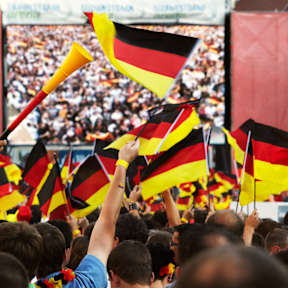 Fans mit Deutschlandflaggen vor einem großen Bildschirm
