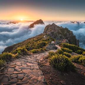 Gepflasterter Fußweg am Pico do Arieiro über den Wolken zum Sonnenaufgang, Madeira. © Marco Bottigelli via Getty Images