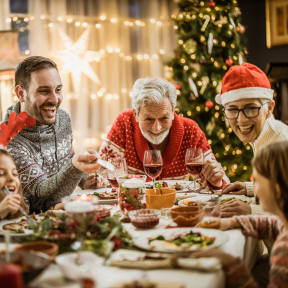 Familie sitzt Weihnachten gemeinsam am Tisch