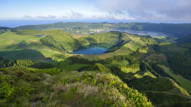 Blick auf eine grüne Landschaft mit ehemaligen Vulkankratern auf den Azoren.